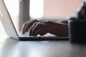 man types on business laptop