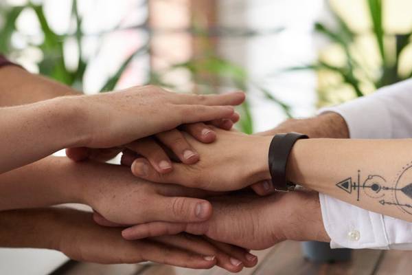 photo of stacked hands to illustrate human firewall