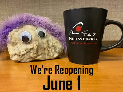 A rock with googley eyes and purple fake fur "hair" sits on a desk next to a TAZ Networks coffee mug. Text reads "We're reopening June 1"