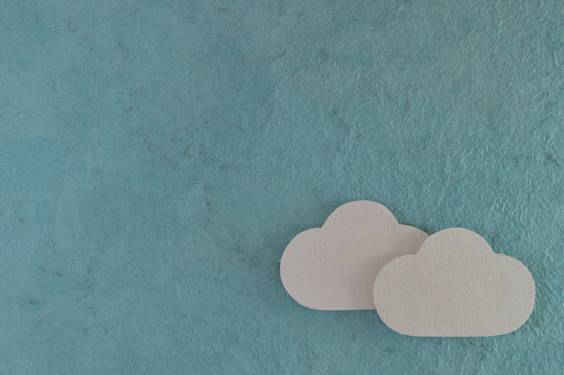 Two small paper "clouds" float on a sky-blue paper backround