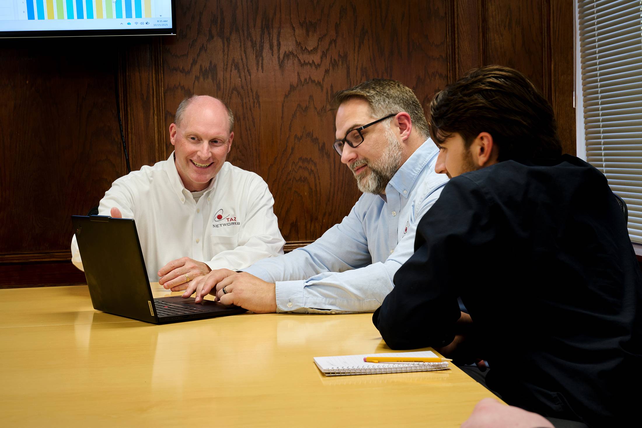 Team reviewing CMMC compliance documentation in a professional office setting